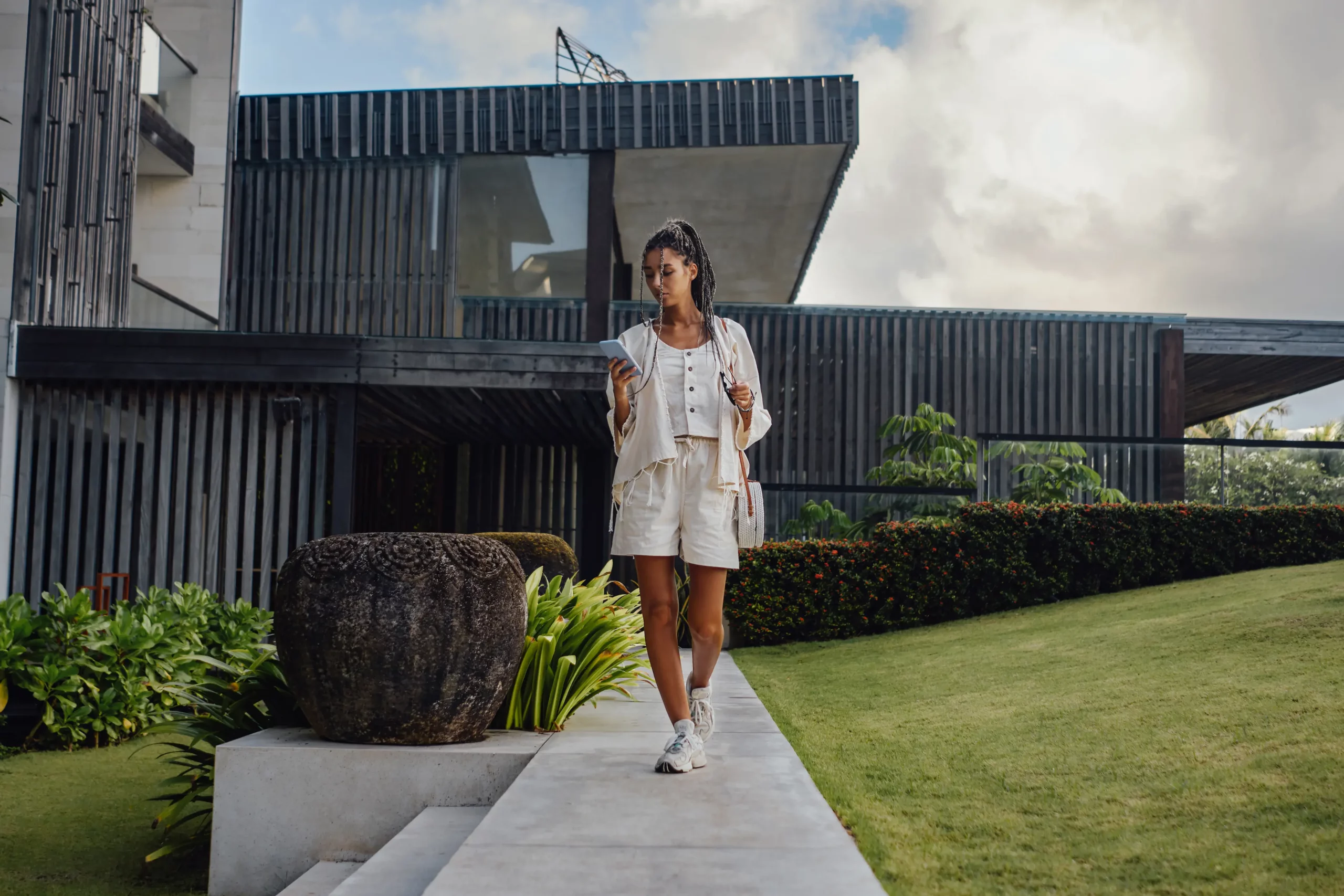 stylish-woman-using-phone-in-modern-suburban-setti-2026-03-17-03-24-45-utc
