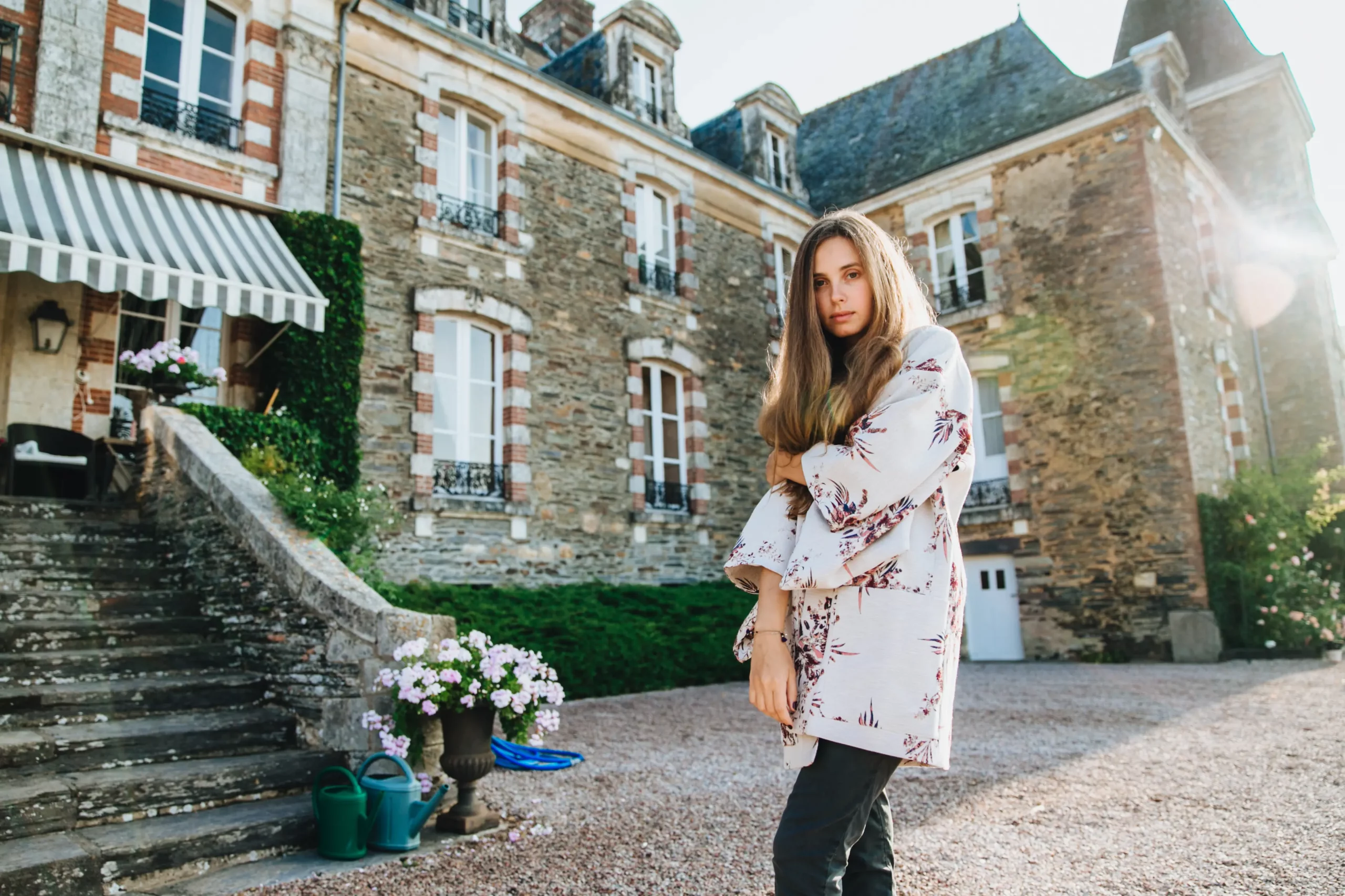young-woman-stands-in-courtyard-near-historic-ston-2026-05-26-18-53-26-utc